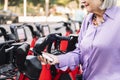 senior woman unlocking rental bike with mobile app