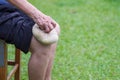 A senior woman uses a Thai herbal compress ball on the knee. Knee pain may cause by muscle strain, tendinosis, osteoarthritis OA Royalty Free Stock Photo