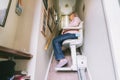 Senior woman using automatic stair lift on a staircase at her home. Medical Stairlift for disabled people and elderly