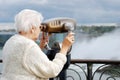 Senior woman using binoculars at niagara falls Royalty Free Stock Photo