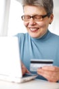 Senior woman using credit card and laptop