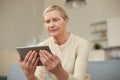 An elderly woman communicates remotely via a tablet with her doctor and takes medications according to his recommendations. Royalty Free Stock Photo