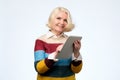 Senior woman using digital tablet surfing web media chatting online, smiling. Royalty Free Stock Photo