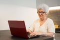 Senior woman using laptop computer at home Royalty Free Stock Photo