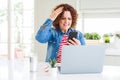 Senior woman using laptop and smartphone stressed with hand on head, shocked with shame and surprise face, angry and frustrated Royalty Free Stock Photo