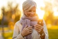 Senior woman using mobile phone outdoors in autumn Royalty Free Stock Photo