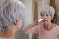 Senior woman using a nasal spray Royalty Free Stock Photo