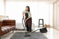 Senior woman using vacuum cleaner at home