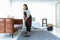 Senior woman using vacuum cleaner at home