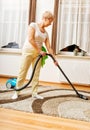 Senior woman vacuuming carpet at home Royalty Free Stock Photo