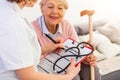 Senior woman is visited by her doctor or caregiver. Female doctor or nurse talking with senior patient. Medicine, age, health care Royalty Free Stock Photo