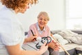 Senior woman is visited by her doctor or caregiver. Female doctor or nurse talking with senior patient. Medicine, age, health care Royalty Free Stock Photo