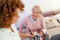 Senior woman is visited by her doctor or caregiver. Female doctor or nurse talking with senior patient. Medicine, age, health care Royalty Free Stock Photo