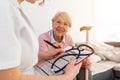 Senior woman is visited by her doctor or caregiver. Female doctor or nurse talking with senior patient. Medicine, age, health care Royalty Free Stock Photo