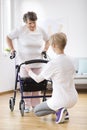 Senior woman with walker trying to walk again and helpful physiotherapist supporting her Royalty Free Stock Photo