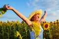 Senior woman walking in blooming sunflower field feeling free and admiring view. Summer vacation