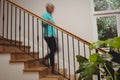 Senior woman walking down stairs Royalty Free Stock Photo