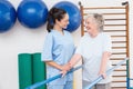 Senior woman walking with parallel bars with therapist Royalty Free Stock Photo