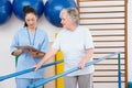 Senior woman walking with parallel bars with therapist Royalty Free Stock Photo