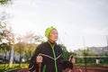 Senior woman walking with walking poles in stadium on a red rubber cover. Elderly woman 88 years old doing Nordic walking Royalty Free Stock Photo