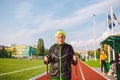 Senior woman walking with walking poles in stadium on a red rubber cover. Elderly woman 88 years old doing Nordic walking Royalty Free Stock Photo