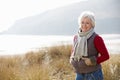 Senior Woman Walking Through Sand Dunes On Winter Beach Royalty Free Stock Photo