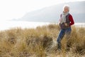 Senior Woman Walking Through Sand Dunes On Winter Beach Royalty Free Stock Photo