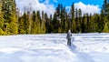 Senior Woman Walking Through The Snow Covered Parking Lot Of Spahats Falls In Wells Gray Provincial Park
