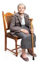 Senior woman with walking stick sitting on chair