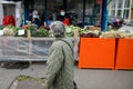 Senior woman walks by a street vegetable market during the covid-19 lockdown