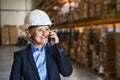 Senior woman warehouse manager or supervisor with smartphone. Royalty Free Stock Photo