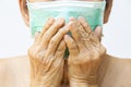 Senior woman wearing face mask, Medical mask, Surgical mask, Two hands closing mouth in white, Front view, Prevention from covid19