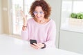 Senior woman wearing glasses and using smartphone very happy and excited, winner expression celebrating victory screaming with big Royalty Free Stock Photo