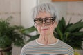 Senior woman wearing three eyeglasses simultaneously Royalty Free Stock Photo