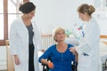 senior woman in wheel chair doing physical therapy with trainer Royalty Free Stock Photo