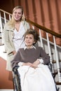 Senior woman in wheelchair with nurse helping Royalty Free Stock Photo