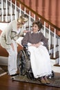 Senior woman in wheelchair with nurse helping Royalty Free Stock Photo