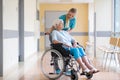 Senior woman in wheelchair with nurse in hospital