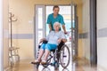 Senior woman in wheelchair with nurse in hospital