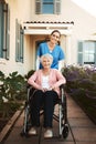 Senior woman, wheelchair and portrait of caregiver in healthcare support or garden walk at nursing home. Happy elderly Royalty Free Stock Photo