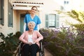 Senior woman, wheelchair and portrait of nurse in healthcare support or garden walk at nursing home. Happy elderly Royalty Free Stock Photo