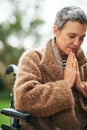 Senior woman in wheelchair, prayer outdoor with worship and God with peace, religion with gratitude and faith. Spiritual Royalty Free Stock Photo