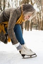 Senior woman in winter clothes putting on old ice skates. Royalty Free Stock Photo