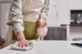 Senior woman wiping kitchen counters while cleaning home