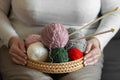 Senior woman& x27;s hands holds a wicker basket with clews and skeins of yarn for knitting, knitting needles. Craft and Royalty Free Stock Photo