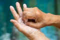 Senior woman& x27;s hands washing her hands using soap foam in step 6 on bokeh blue swimming pool, Prevention from covid19