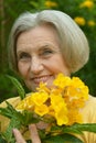 Senior woman with yellow flowers Royalty Free Stock Photo