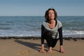 Mature woman yoga sun salutation on the beach Royalty Free Stock Photo