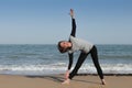 Mature woman yoga triangle on the beach