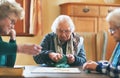 Senior women, board game and nursing home friendship or old people, thinking and play games together in retirement Royalty Free Stock Photo